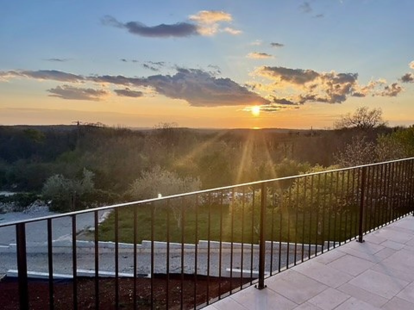 The sun going down over the fields, seen from the terrace railing