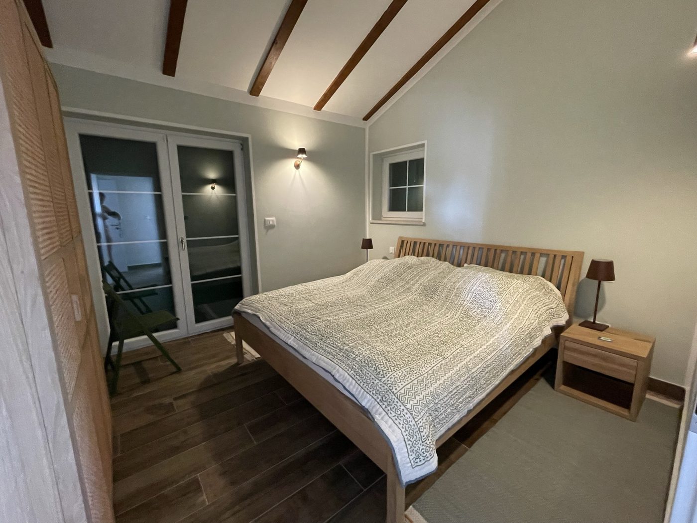 The second bedroom with a 180 by 200 bed and doors to the terrace