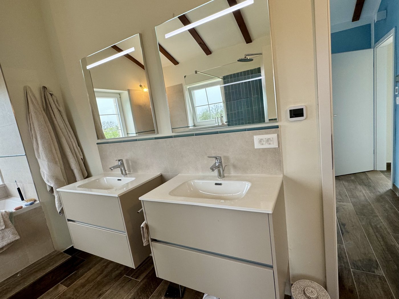 The master bathroom with twin basins and mirrors under the beams
